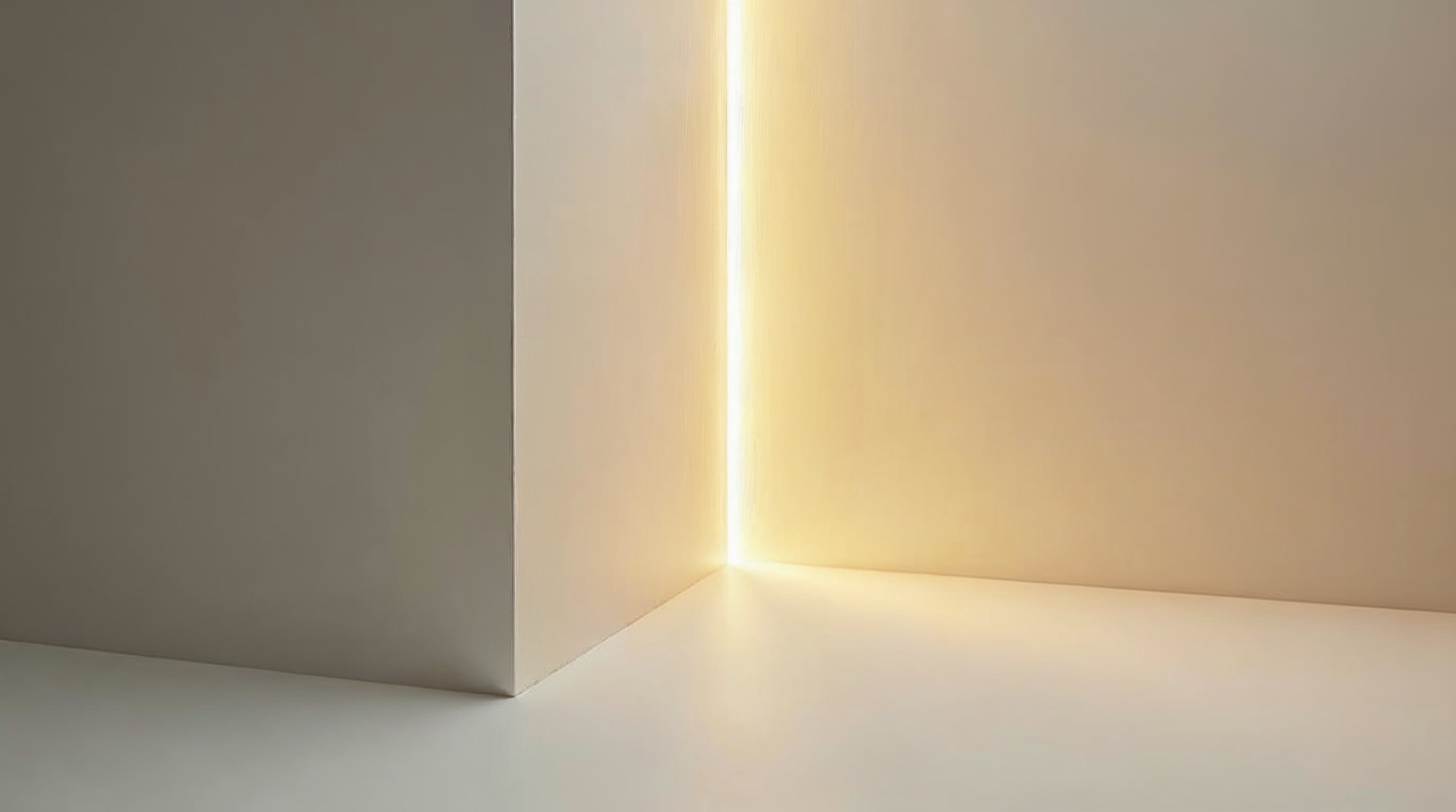 Ein heller Raum endet an einer Wand, durch einen schmalen Spalt fällt warmes Licht.